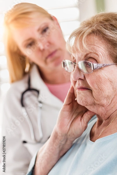 Fototapeta Melancholy Senior Adult Woman Being Consoled by Female Doctor or Nurse