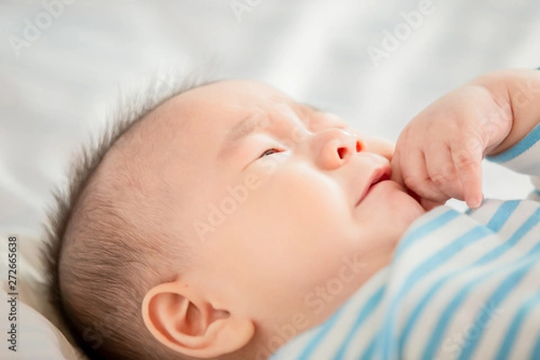 Fototapeta baby lying on the bed