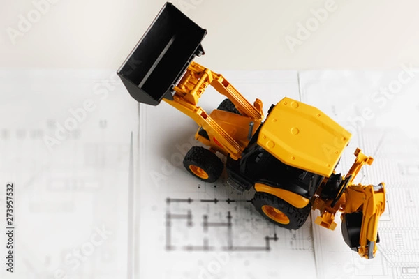 Fototapeta tractor toy on housing construction blueprint