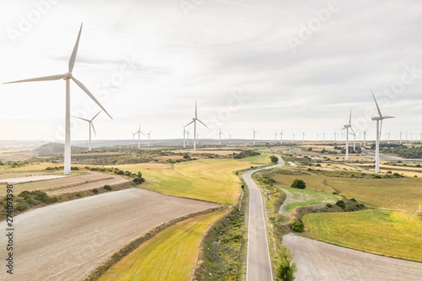 Fototapeta wind turbine and road at sunset