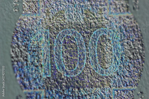 Fototapeta Protective watermark on a hundred euro bill in macro. protection against counterfeiting of banknotes. hologram. detail of paper money close up