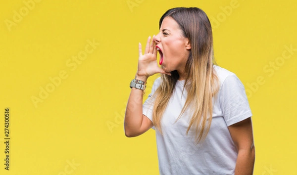 Obraz Young beautiful woman casual white t-shirt over isolated background shouting and screaming loud to side with hand on mouth. Communication concept.