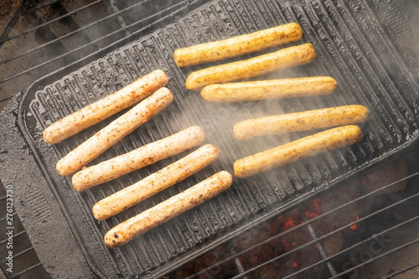 Fototapeta Cooking sausages on the barbecue grill. Grilled sausages