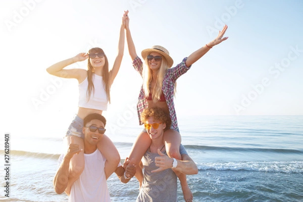 Fototapeta Happy smiling couples playing at the beach