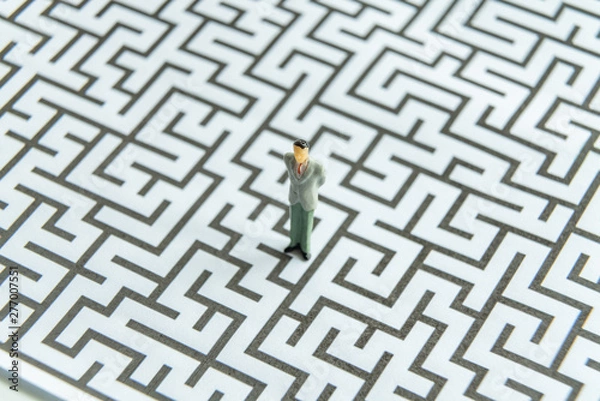 Fototapeta Miniature people: Businessman standing on start point of maze