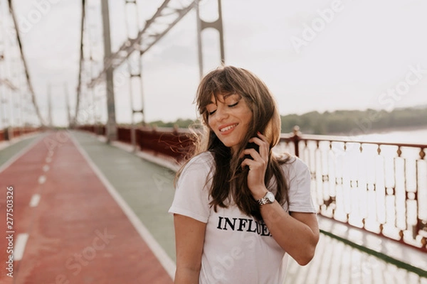 Obraz Portrait of magnificent romantic female model in white t-shirt walking on the morning walking