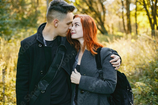 Fototapeta Cute couple in a park. Lady with red hair. Guy with a guitar