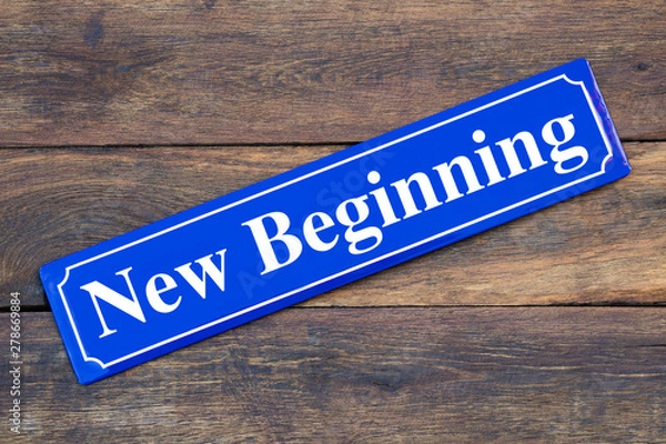 Fototapeta New Beginning street sign on wooden background