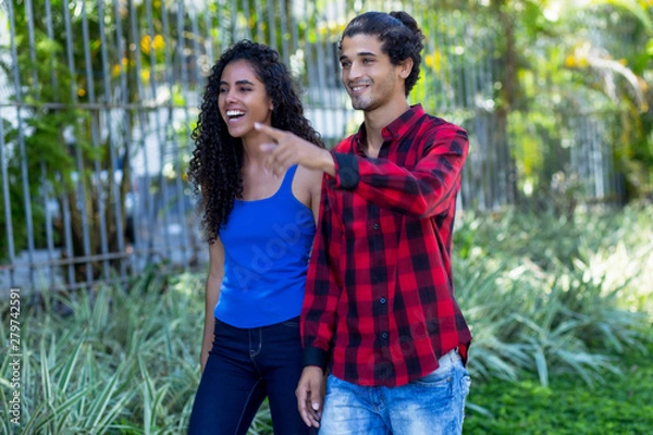 Fototapeta Laughing brazilian hipster couple in city