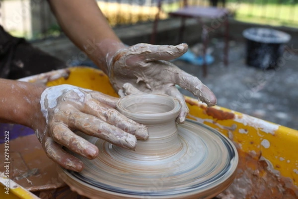 Fototapeta Master of ceramics. We work with clay. The master ceramist teaches the student. Craftsman hands sculpts clay