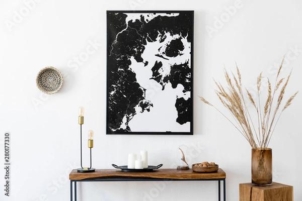 Fototapeta Stylish and cozy scandinavian interior of living room with wooden console, ring on the wall, cube, flowers and elegant personal accessories. Black mock up poster map. Design home decor. Template. 