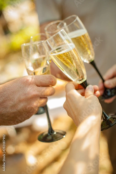 Fototapeta Corporate party sparkling champagne glasses. Hands with glasses of champagne