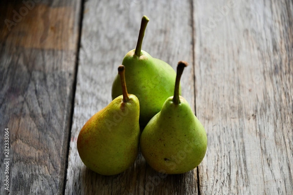 Fototapeta Pears lie on old oak boards.