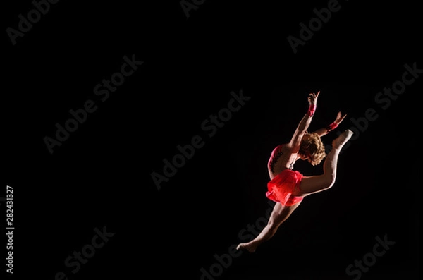 Fototapeta Young beautiful dancer gymnastics jumping in studio