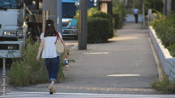 Fototapeta young woman walking on the street