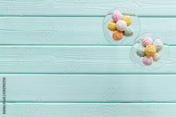 Fototapeta Ice-cream scoops in vase on mint green wooden backgroung top view mockup