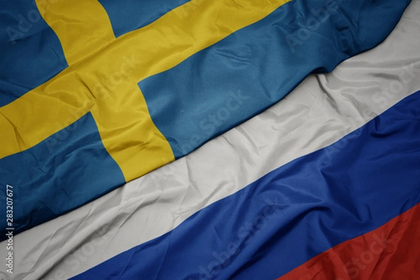 Fototapeta waving colorful flag of russia and national flag of sweden.