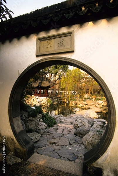 Obraz View of Yuyuan Gardens through the circular door in a traditional Chinese wall in Shanghai People's Republic of China