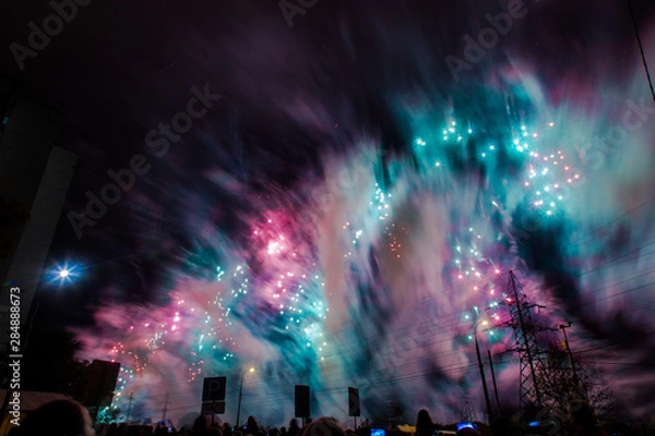 Fototapeta Red, green and blue festive fireworks on a black background. Abstract holiday background. International Fireworks Festival ROSTEC