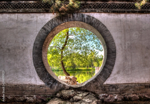 Fototapeta Looking through a circular doorway to a lake at Bishushanzhuang Imperial Mountain Resort.