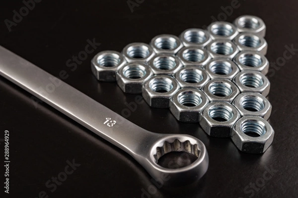 Fototapeta Nickel-plated nuts and wrenches on a workshop table. Tools in a mechanical workshop.