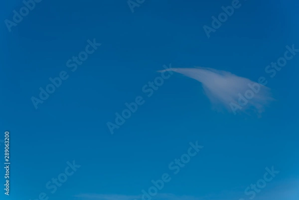 Fototapeta Single Swoosh Cloud in a Clear Blue Sky Perfect for Background