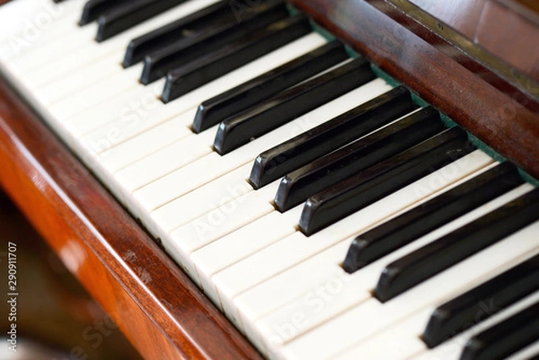 Fototapeta Old brown piano close-up. The keys of an old vintage piano