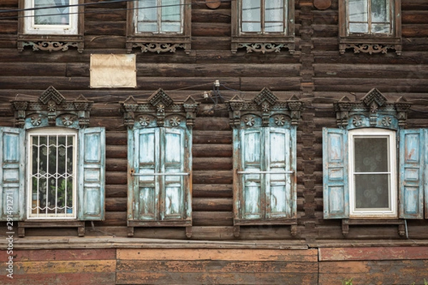 Fototapeta Window with the wooden carved architrave in the old wooden house in the old Russian town. Irkutsk