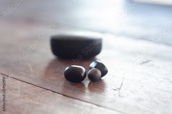 Fototapeta Wireless headphones on wooden background