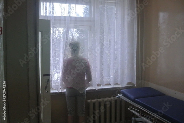 Fototapeta  girl in front of the window at the hospital in the afternoon