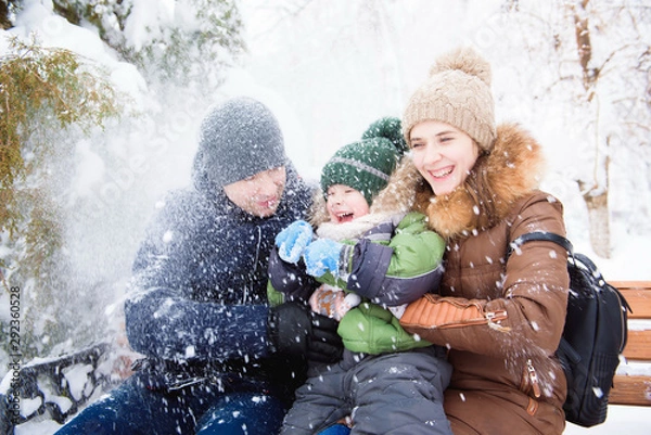 Fototapeta happy family having fun and playing with snow in forest