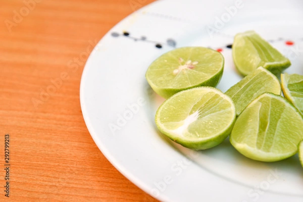 Fototapeta Lime in white dish on wood blackground