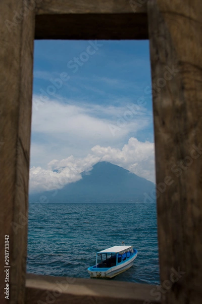 Fototapeta Enmarcado del Lago y Volcán Atitlán ilustrando la idea de un paisaje vacacional, un destino turístico para visitar y disfrutar al aire libre