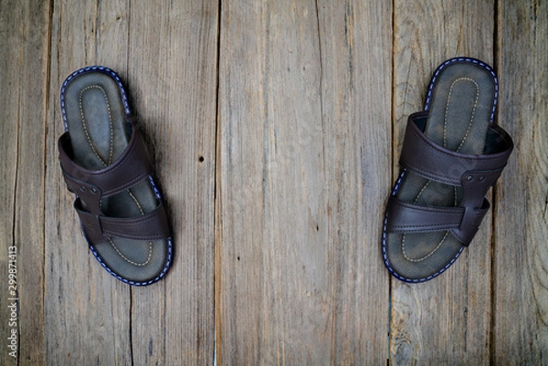 Fototapeta brown leather slippers on wood background,top view