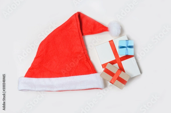 Fototapeta Santa hat with gifts on a light background