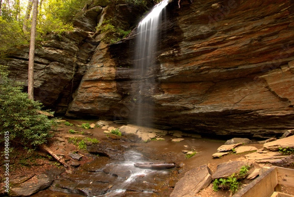 Fototapeta Waterfall streaming down a rocky overhang in the fall months of the year