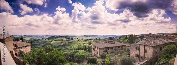 Fototapeta Beautiful cumulus-clouded panorama from the top of the wall of the medieval tuscan town San Gimignano