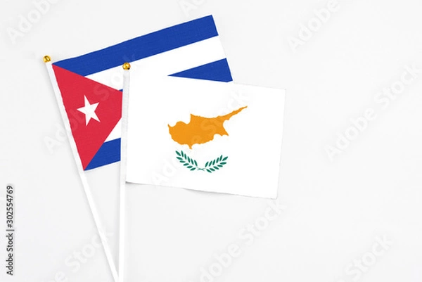 Fototapeta Cyprus and Cuba stick flags on white background. High quality fabric, miniature national flag. Peaceful global concept.White floor for copy space.