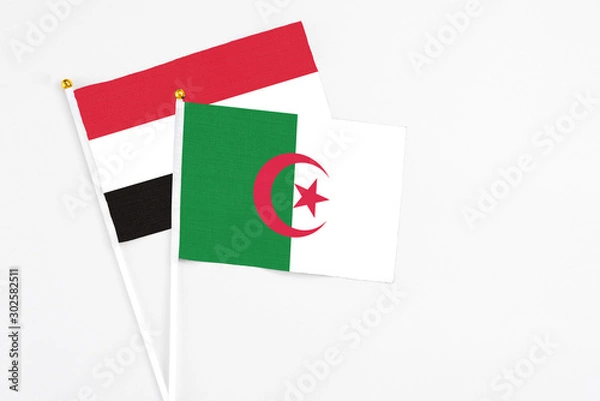 Fototapeta Algeria and Egypt stick flags on white background. High quality fabric, miniature national flag. Peaceful global concept.White floor for copy space.