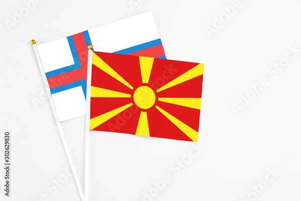 Fototapeta Macedonia and Faroe Islands stick flags on white background. High quality fabric, miniature national flag. Peaceful global concept.White floor for copy space.