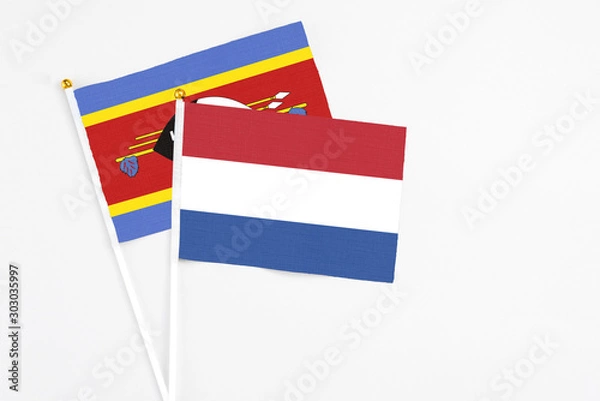 Obraz Netherlands and Swaziland stick flags on white background. High quality fabric, miniature national flag. Peaceful global concept.White floor for copy space.