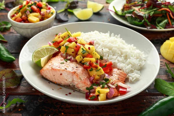 Fototapeta Salmon with mango salsa and white rice on plate