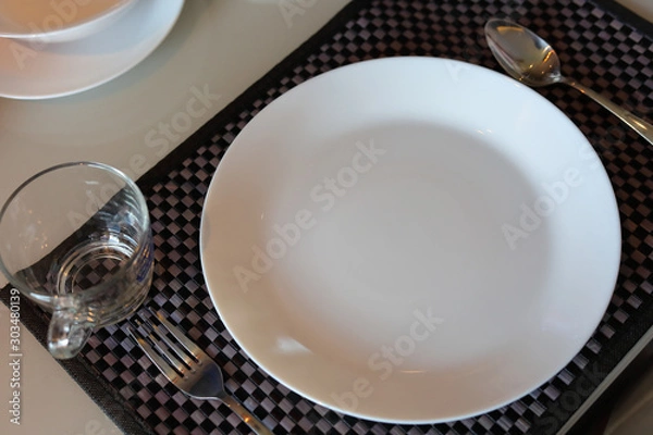 Fototapeta white dish ware sets arrange on dinner table inside eating room of modern home interior