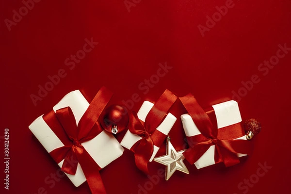 Fototapeta Christmas card with gifts on a red background. with a place for congratulations.