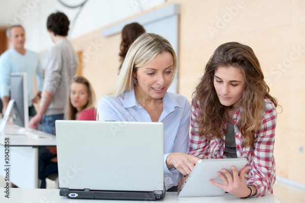 Fototapeta Portrait of teacher and teenage girl in computing class