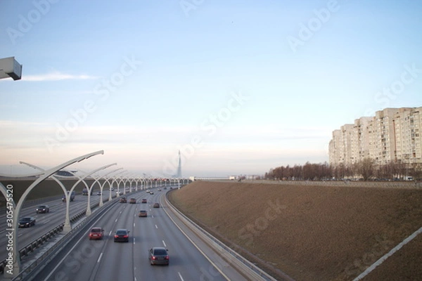 Fototapeta Expressway on the outskirts of the city on a fall evening