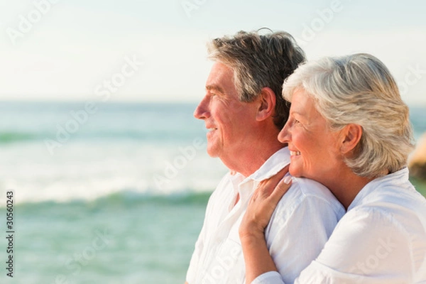 Fototapeta Woman hugging her husband at the beach