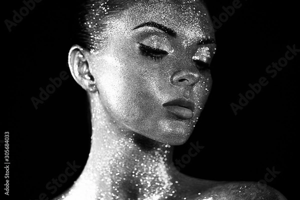 Fototapeta Fashion model woman in bright sparkles and lights posing in studio. Portrait of beautiful sexy woman. Art design glitter glowing make up. Black and white photography