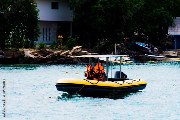 Fototapeta Motorized boat, floating in the water  On the boat there is a life jacket.