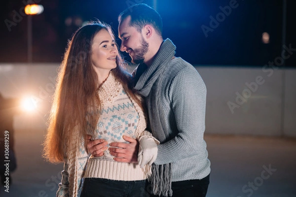 Fototapeta Date lovers in winter rink skates. Concept of Christmas holidays, caring for your loved one.